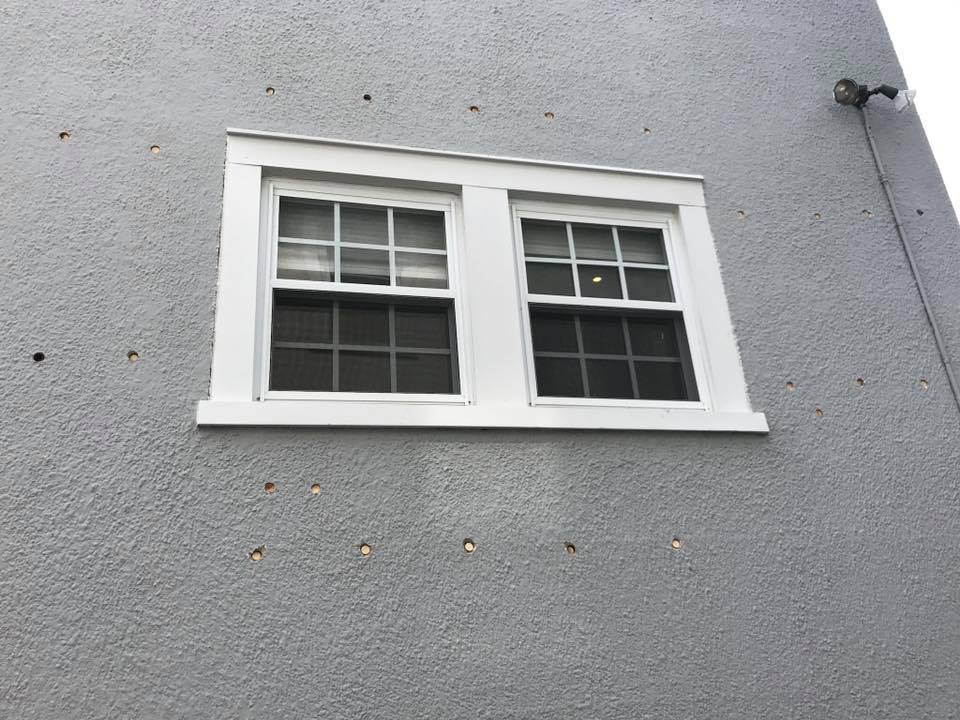 Small wall access openings around an exterior window.