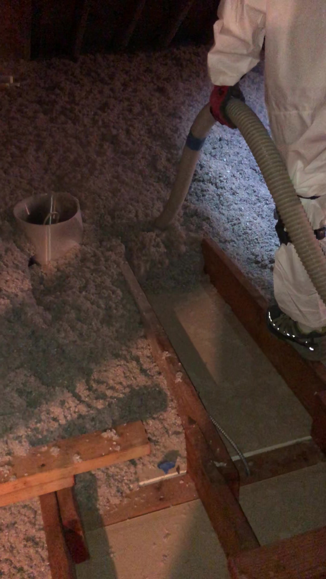 Loose-fill insulation being installed in an attic floor cavity.